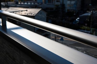 Şehir balkon manzarasında güneş ışığını yansıtan metal korkuluklar