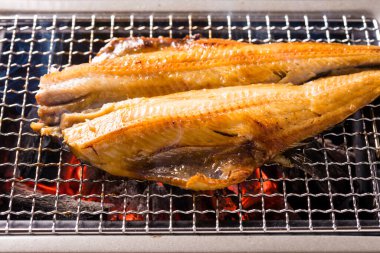 Izgarada balık pişirmek, manzarayı kapatın.