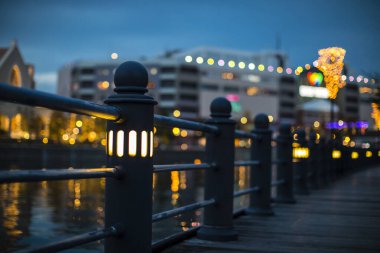 Şehir ışıklarıyla rıhtım boyunca aydınlatılmış lamba direği