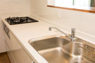 Beyaz ve gri mutfak lavabosu ve musluğu odada.