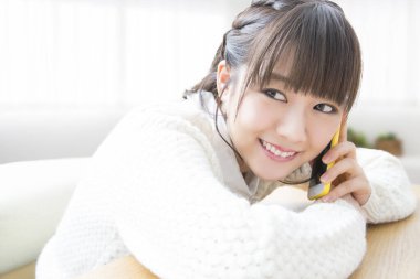 Akıllı telefondaki gülümseyen Asyalı kadın. 