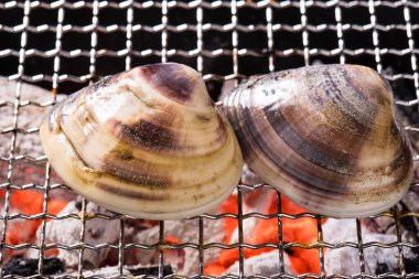 Izgarada iki midye, mangalda deniz ürünleri.