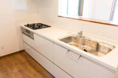 Beyaz ve gri mutfak lavabosu ve musluğu odada.