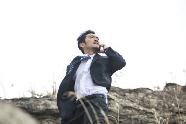 Genç Asyalı işadamı telefonda konuşuyor.