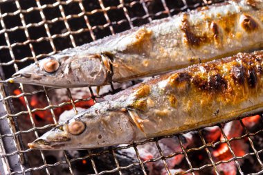 Izgarada balık pişirmek, manzarayı kapatın.