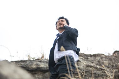 Genç Asyalı işadamı telefonda konuşuyor.