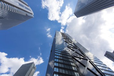 Mavi gökyüzüne uzanan modern cam gökdelenlerin alçak açılı görüntüsü