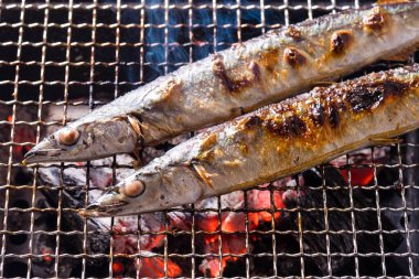 Izgarada balık pişirmek, manzarayı kapatın.