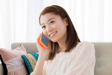 Evde kanepede Smartphone kullanan kadın 