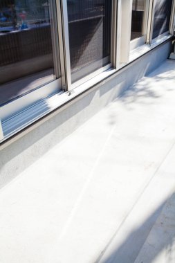 Güneş ışığı modern bina dış duvarı boyunca keskin gölgeler bırakıyor.