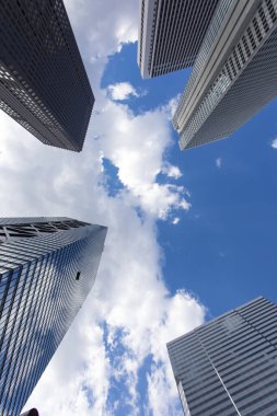 Mavi gökyüzüne uzanan modern cam gökdelenlerin alçak açılı görüntüsü