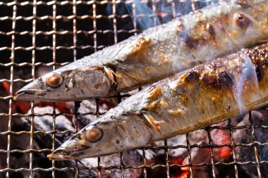 Izgarada balık pişirmek, manzarayı kapatın.