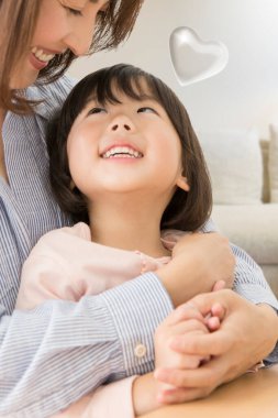 Mutlu anne ve kızı evde sarılıyorlar. 