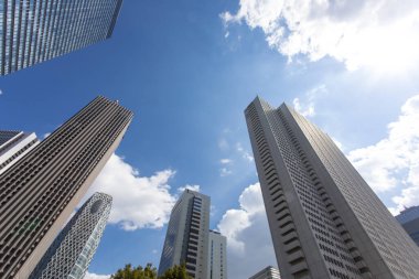 Mavi gökyüzüne uzanan modern cam gökdelenlerin alçak açılı görüntüsü