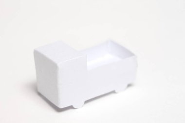 Beyaz arka planda kağıttan yapılmış bir oyuncak araba.