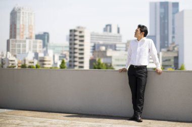 Şehre bakan yakışıklı genç iş adamının portresi     