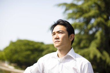 Parka bakan yakışıklı genç iş adamının portresi.