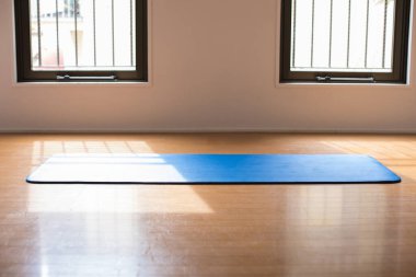 Yerde yoga minderi var.