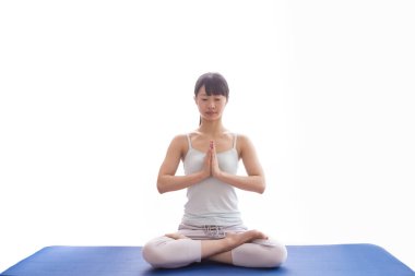 Lotus pozisyonunda meditasyon yapan Asyalı kadın.