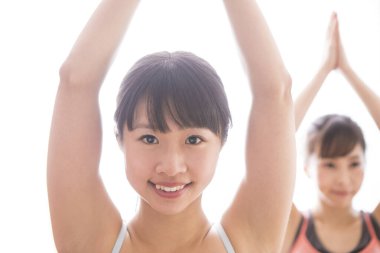 Genç Asyalı kadınlar yoga egzersizi yapıyor.