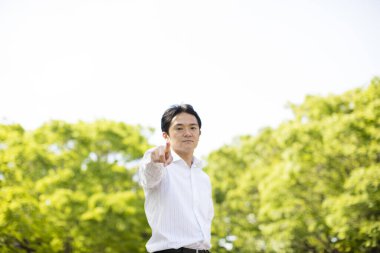 Parkta kameraya bakan yakışıklı genç iş adamının portresi.