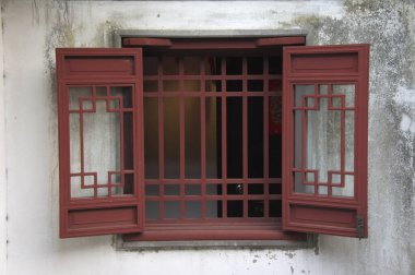 Geometrik desenli kırmızı ahşap pencere çerçevesi dışa açılıyor