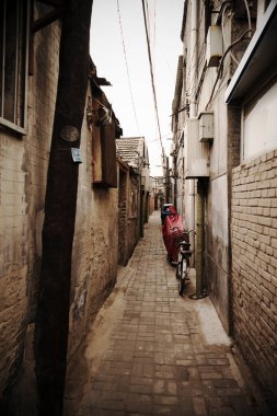 Park halindeki bisikletli eski tuğla binalar arasındaki dar yol