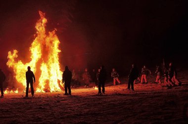Geleneksel halk geceleri ateşin yanında dans eder.                      