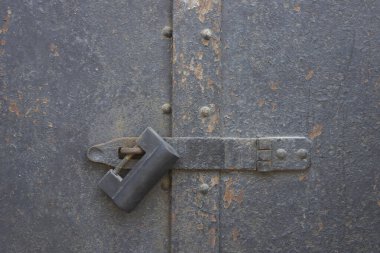 Gri beton arka planda paslı metal kapı kolu.. 