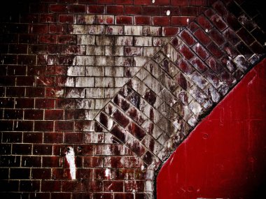 Yıpranmış tuğla duvar boyayı ve tuğlaları gösteriyor.