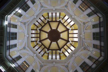 Karmaşık mimari detaylarla süslü geometrik tavana doğru bakıyorum.