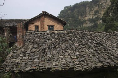 Kayalık uçurumun yanında kiremit çatılı geleneksel tuğla ev