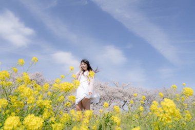 Kiraz çiçeği arkaplan manzaralı güzel genç kız. 