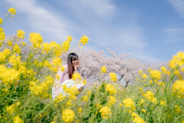 Kiraz çiçeği arkaplan manzaralı güzel genç kız. 