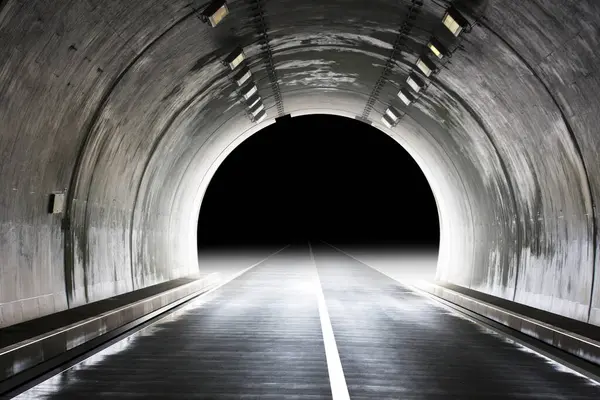 Işık ve asfalt yolu olan bir tünel.