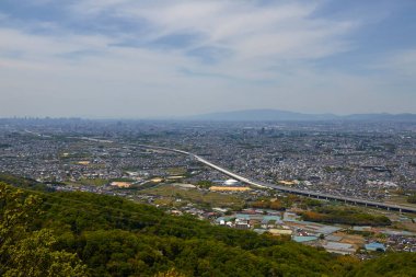 Gündüz vakti bulutlu gökyüzü altındaki modern Japon şehrinin havadan görünüşü 