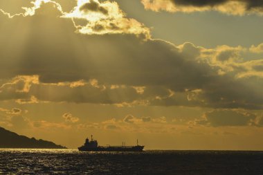 Güneş ışınları ve deniz üzerindeki bulutlar. Denizin üzerinde güzel bir gün batımı.