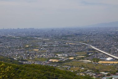 Gündüz vakti bulutlu gökyüzü altındaki modern Japon şehrinin havadan görünüşü 