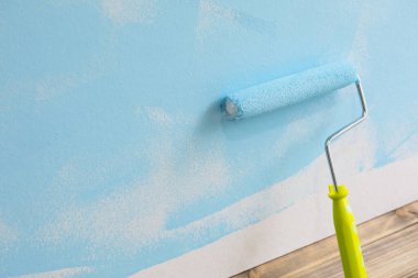 Beyaz arkaplanda mavi renkli boya silindiri