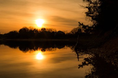 Doğanın arka planında gölün üzerinde güzel bir gün batımı