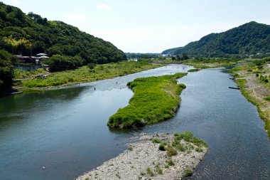 Bulutlu gökyüzünün altındaki yeşil dağların havadan görünüşü