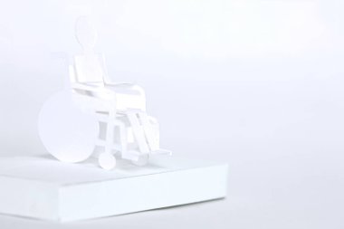 Arka planda kağıt tekerlekli sandalyedeki beyaz kağıt adam.
