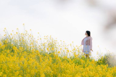 Güzel Asyalı kadın bahçede poz veriyor. 