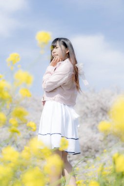 Kiraz çiçeği arkaplan manzaralı güzel genç kız. 