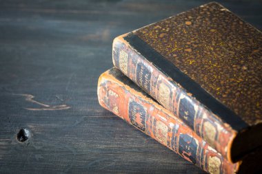 Eski kitaplar, koyu ahşap masa.