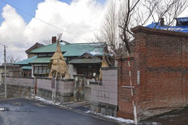 Kış mevsiminde geleneksel evin yanındaki eski tuğla duvar