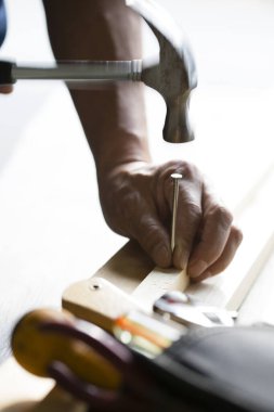 Marangoz çekiçle ahşap kalasla çalışır.