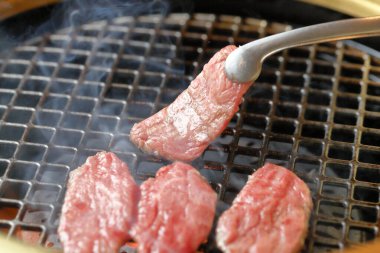 Izgarada pişen lezzetli etin yakın görüntüsü 