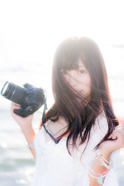 Deniz manzaralı güzel bir fotoğrafçı kız.