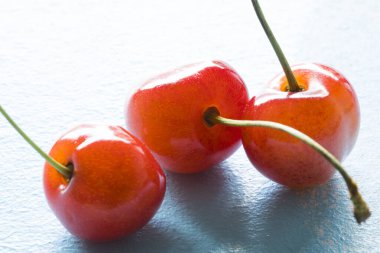 Beyaz arka planda üç taze vişne